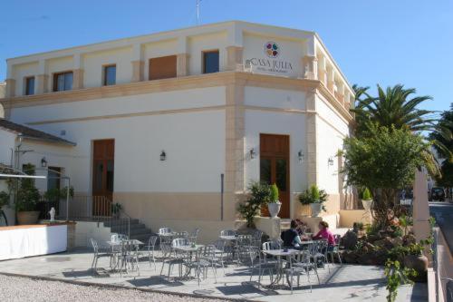 een gebouw met tafels en stoelen ervoor bij Hotel Restaurante Casa Julia in Parcent