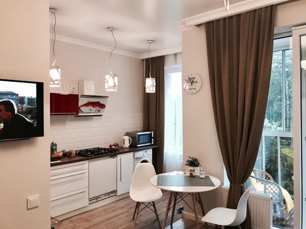 スヴェトロゴルスクにあるLakeCity Apartmentsのキッチン(テーブル、小さなテーブル、椅子付)