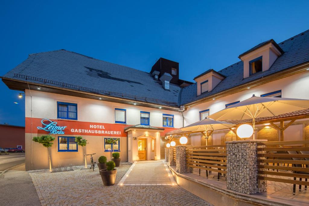 Hotel Leimer Bräu في Lenzing: فندق فيه مطعم ومبنى