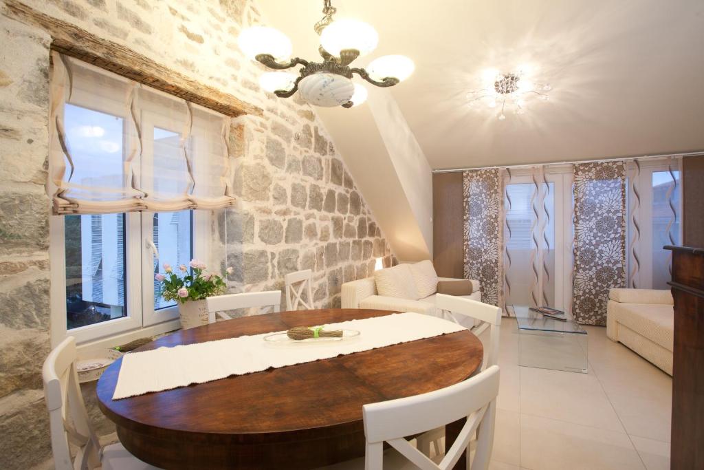 a dining room with a table and chairs and windows at Apartments Tin in Split
