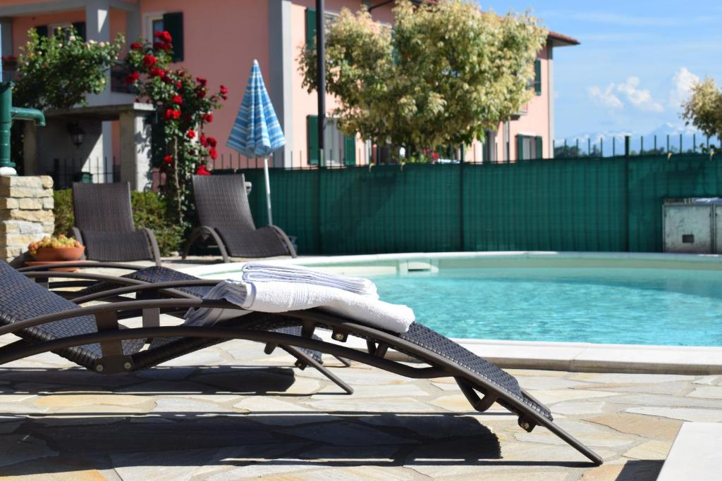 a pool with chairs and a table and a swimming pool at Bene&Breakfast in Bene Vagienna
