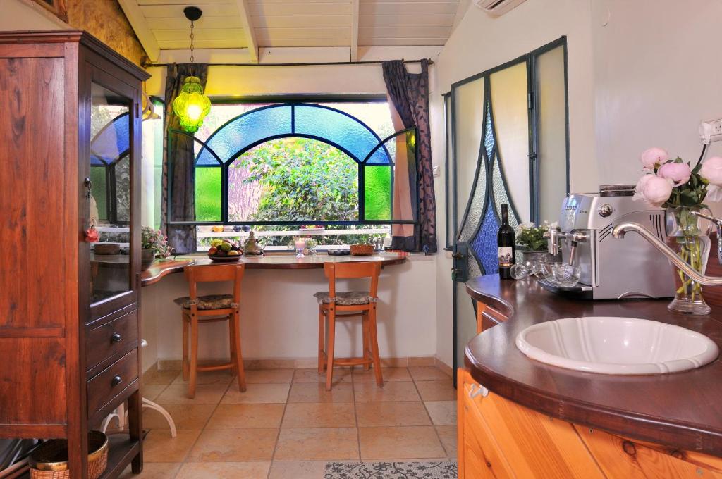 a kitchen with a sink and a counter with a window at Pina Balev Inn in Rosh Pinna