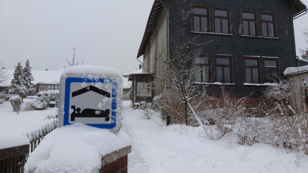 a snow covered sign in front of a house at Alte Schule in Tambach-Dietharz