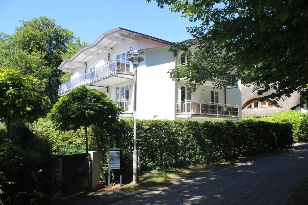 un edificio blanco con una valla delante en Strandwohnungen Sellin, en Ostseebad Sellin