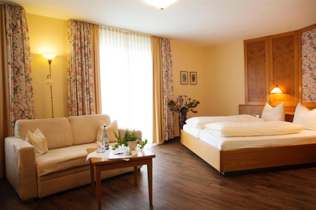 una camera d'albergo con letto e divano di Hotel & Restaurant Dornweiler Hof a Illertissen