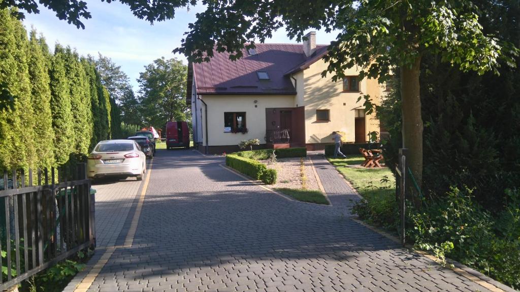 Wczasowa 73 في Karwieńskie Błoto Drugie: a car driving down a road next to a house