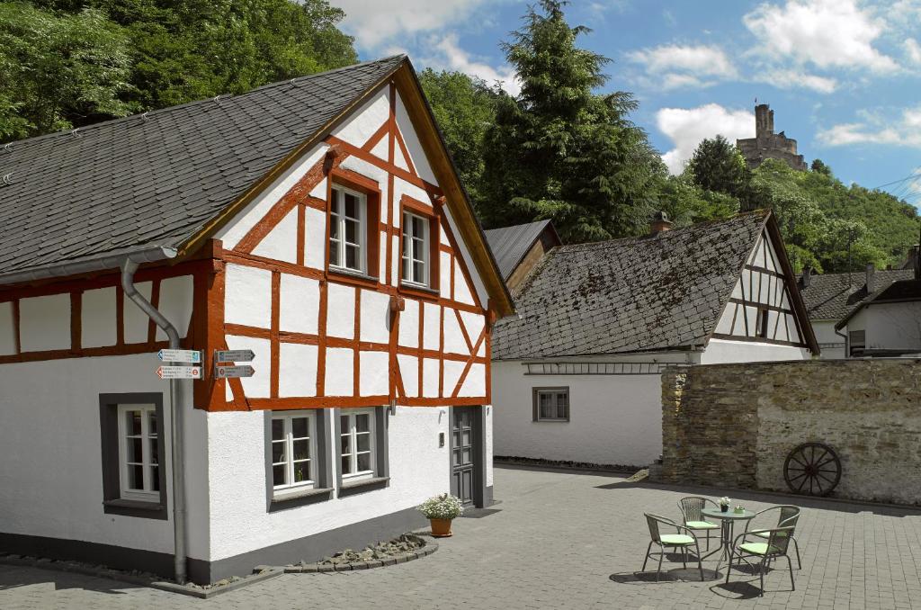 in einem weißen und orangefarbenen Gebäude mit Stühlen und einem Tisch in der Unterkunft Rhein-Mosel-Ferienhaus in Brodenbach