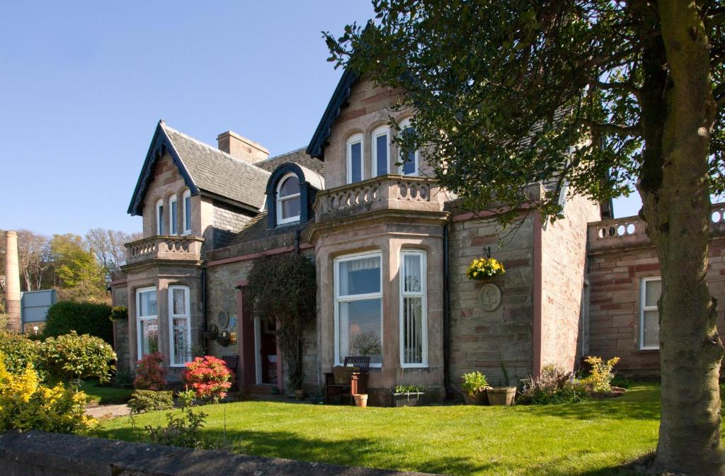 una casa con un árbol delante de ella en Royston Guest House Inverness, en Inverness