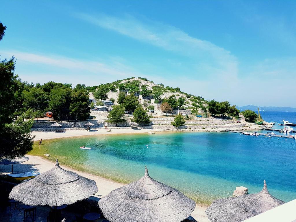 a view of a beach with umbrellas and the ocean at Mobile home Lučan in Drage