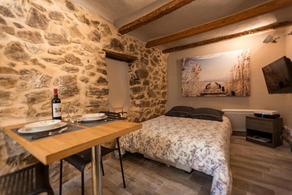 Un dormitorio con una cama y una mesa con una botella de vino en Studio Suquet Saint Antoine, en Cannes