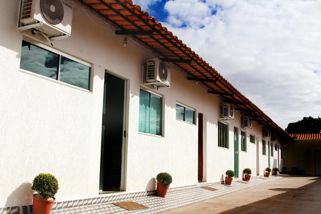 a white building with potted plants in front of it at Hotel New in Formosa