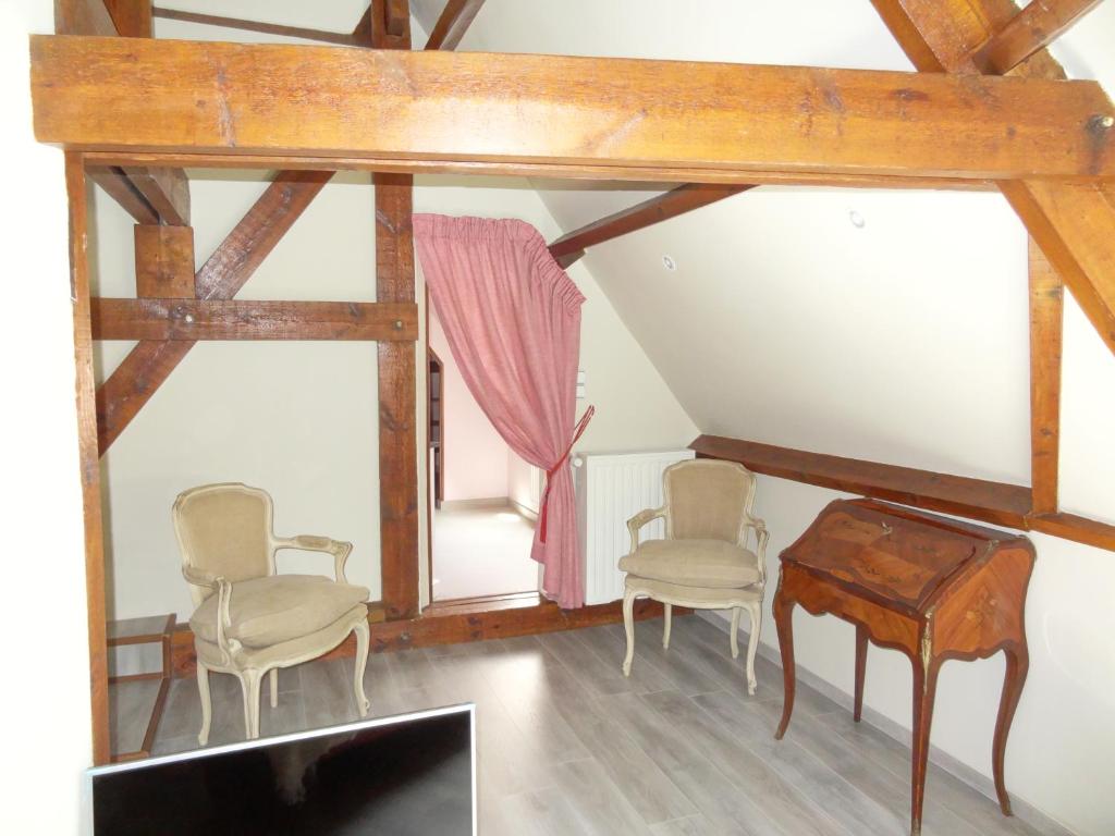 um quarto com duas cadeiras, uma mesa e uma janela em Le chateau des eglantines em Montignies-le-Tilleul