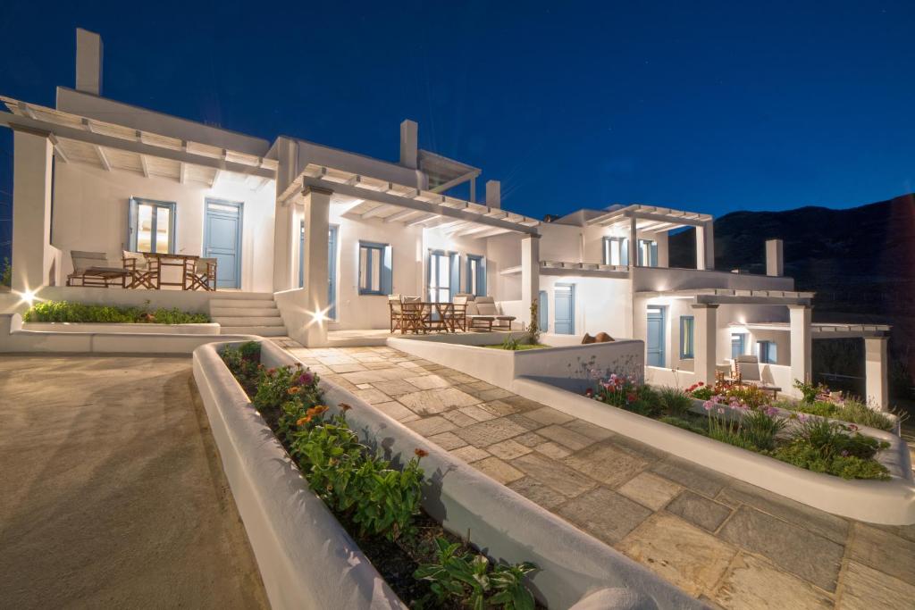 a large white house with a patio at night at Almyra Guesthouse in Skiros