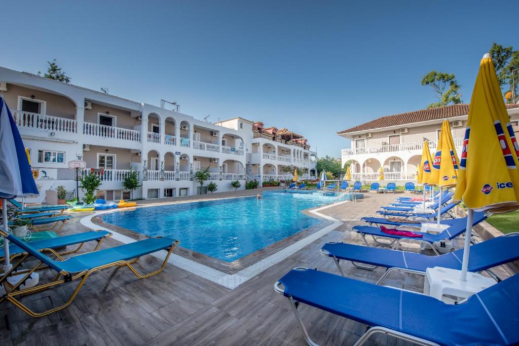 a pool at a hotel with chairs and umbrellas at Ragias Studios in Tsilivi