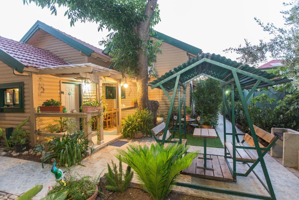 una casa con un columpio en el patio en Leyad Hashmura Lodging, en Yesod Hamaala
