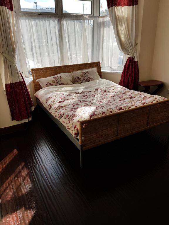 a bed sitting in a bedroom with a window at Cozy Guest House in Luton