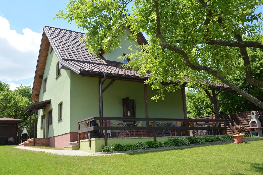 una casa verde y blanca con un árbol en Augustów Summer Camp, en Augustów