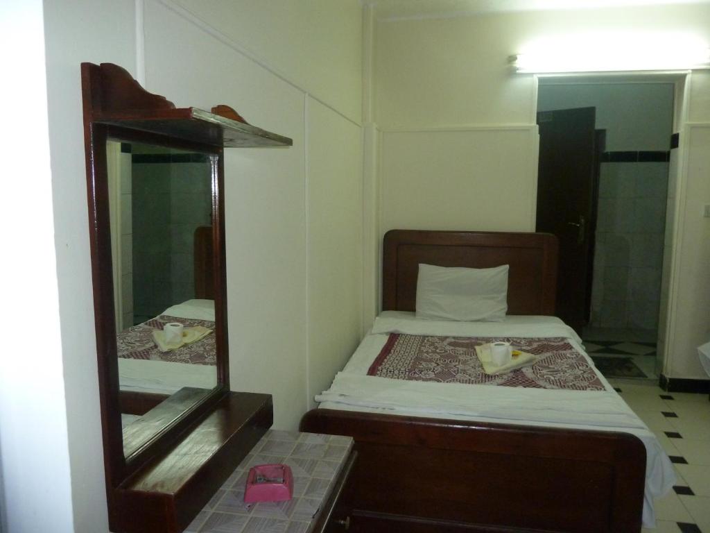 a small bedroom with a bed and a mirror at Venus Hostel in Cairo