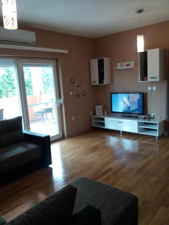 ein Wohnzimmer mit einem Flachbild-TV und einem Sofa in der Unterkunft Apartman B&D Sukosan in Sukošan