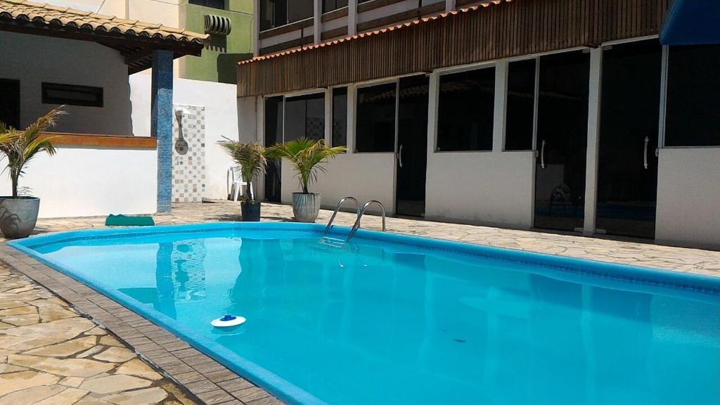 a large blue swimming pool in front of a building at Pousada Boa Vida in Maceió