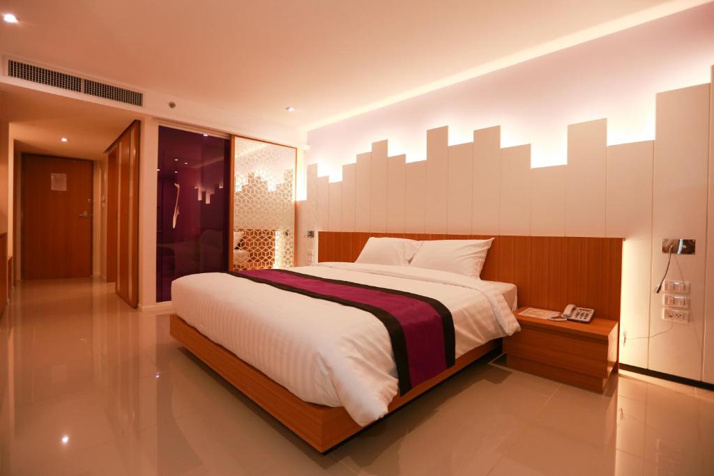 A bed or beds in a room at The Whisper Hotel