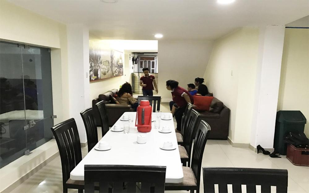 un comedor con mesa, sillas y personas en Hotel Santa Maria, en Ica