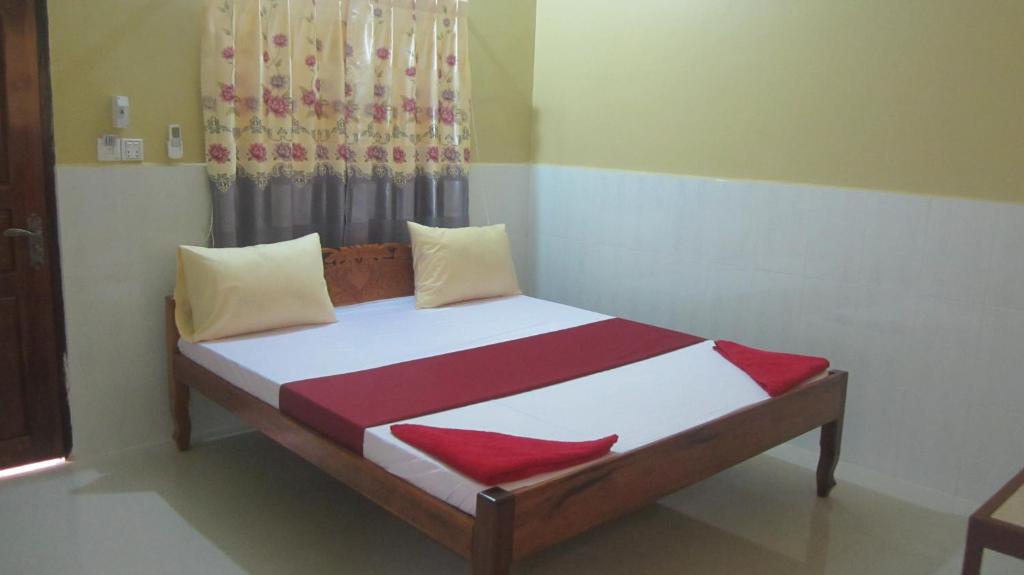 磅湛的住宿－Phalla Riverside，一间卧室配有红色和白色床单