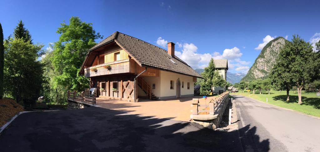 a building on the side of a road next to a mountain at Apartment Markič in Bohinj