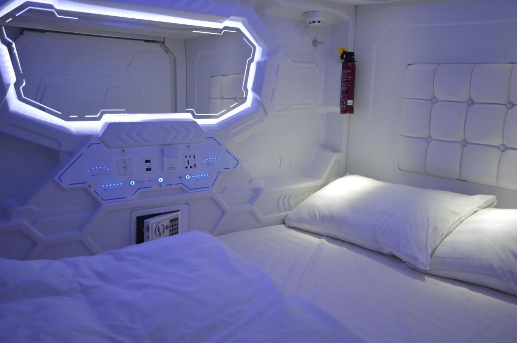 ウラジオストクにあるカプセル ホテル ゾディアックのベッドと窓が備わる小さな客室です。