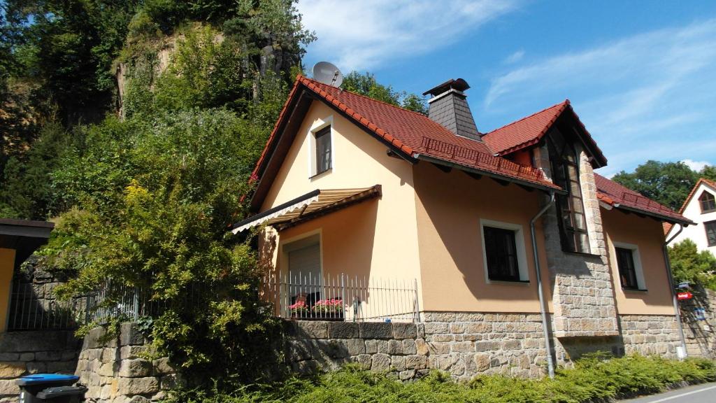 una pequeña casa amarilla con una pared de ladrillo en Haus Ferienromantik, en Pirna