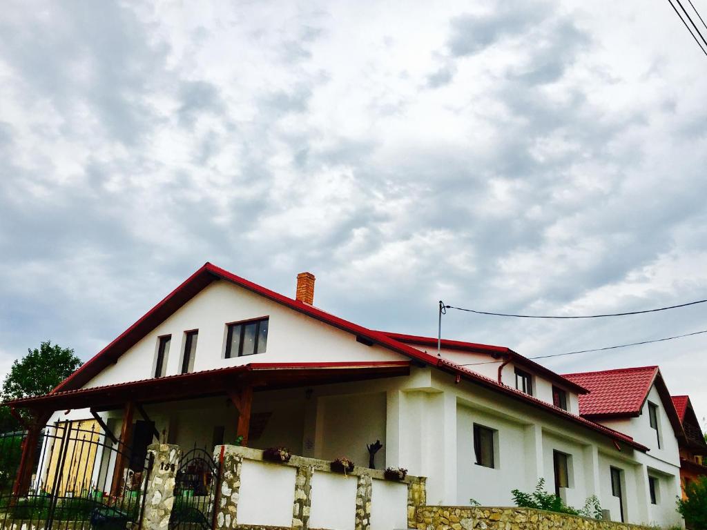 a white house with a red roof at Casa de Vacanta Potoc in Potoc