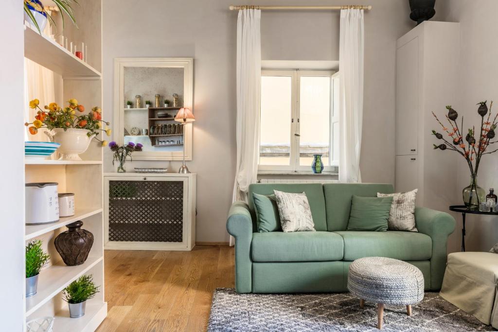 a living room with a green couch and a window at Stence Apartment in Lucca