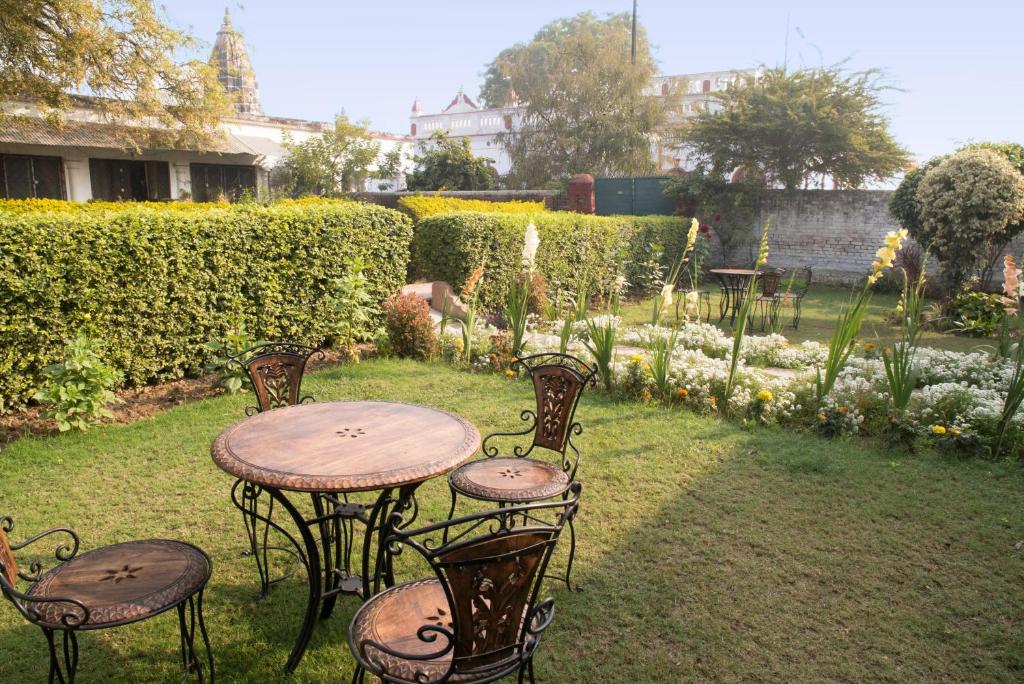 a table and chairs in a yard with a garden at Panchkote Raj Ganges in Varanasi
