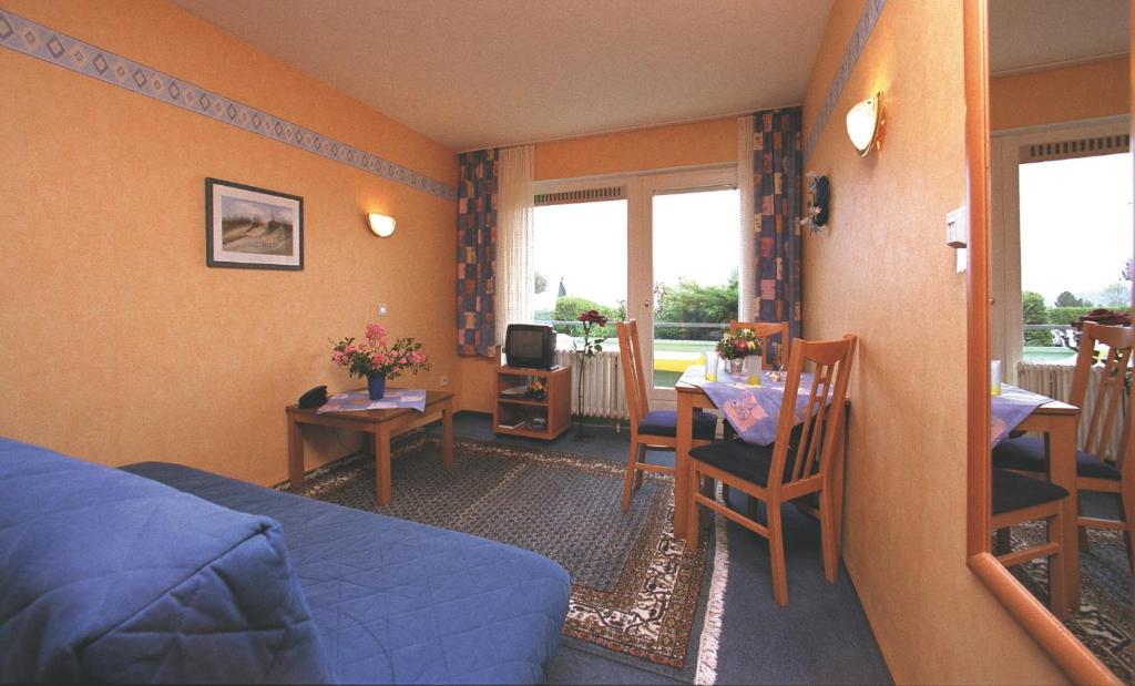 ein Schlafzimmer mit einem Bett und einem Tisch sowie ein Esszimmer in der Unterkunft Haus Mariann in Bad Wildungen
