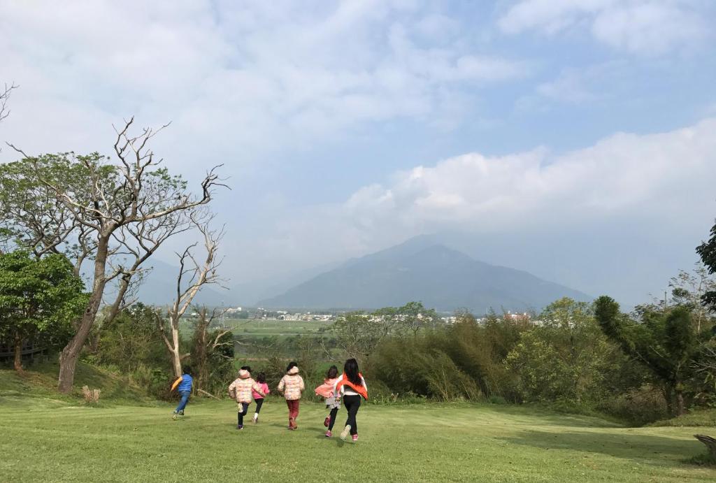a group of people walking in a field at 玉蟾園民宿 寵物友善 YuChanYuan B&amp;B in Chishang
