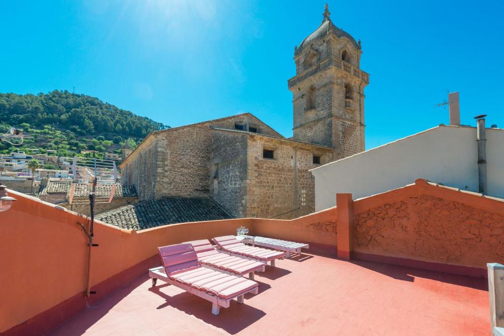 a group of benches on the roof of a building with a clock tower at Darrera Es Campanar in Bunyola