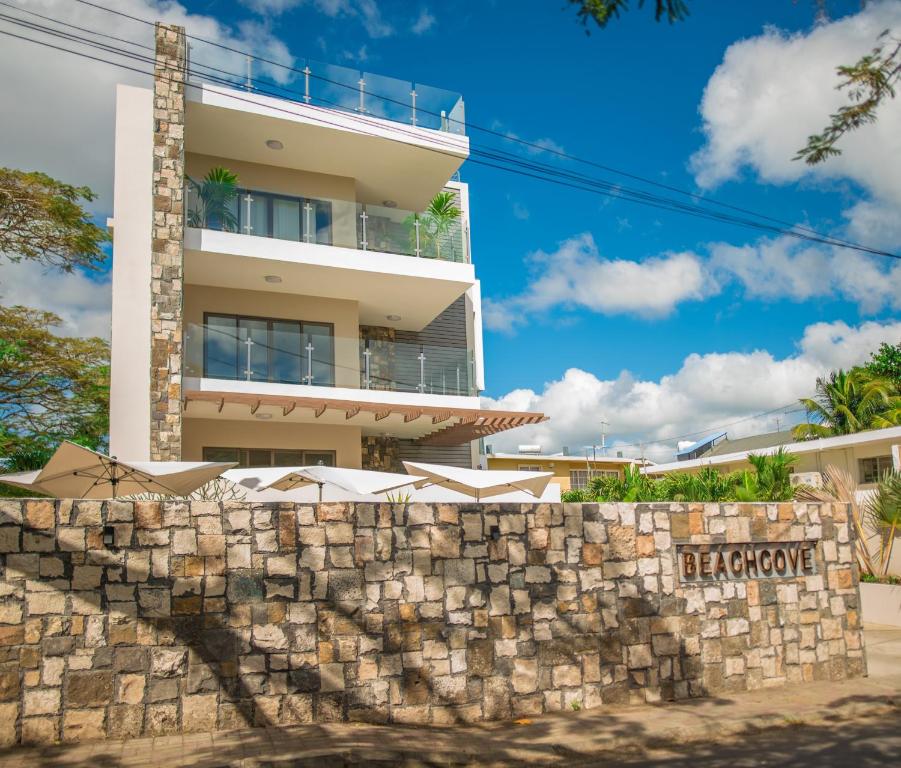 una pared de piedra frente a un edificio en Beachcove No 6, en Grand Baie