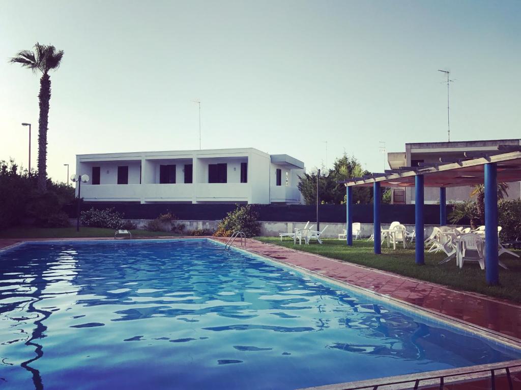 una piscina con una casa sullo sfondo di Mya Vacanze a Torre dell'Orso