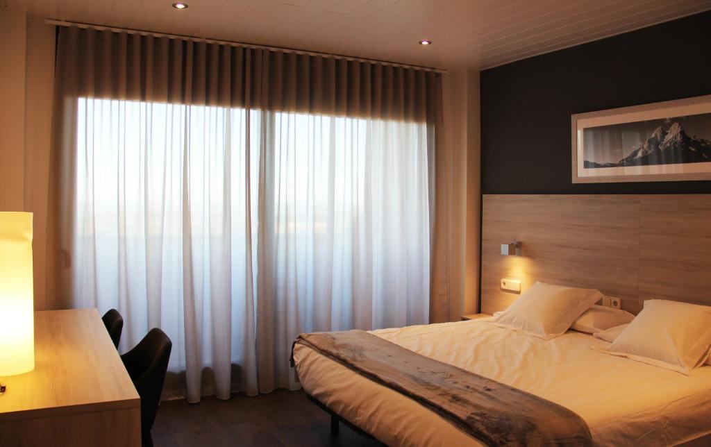 a bedroom with a bed and a large window at Can Puig in Solsona