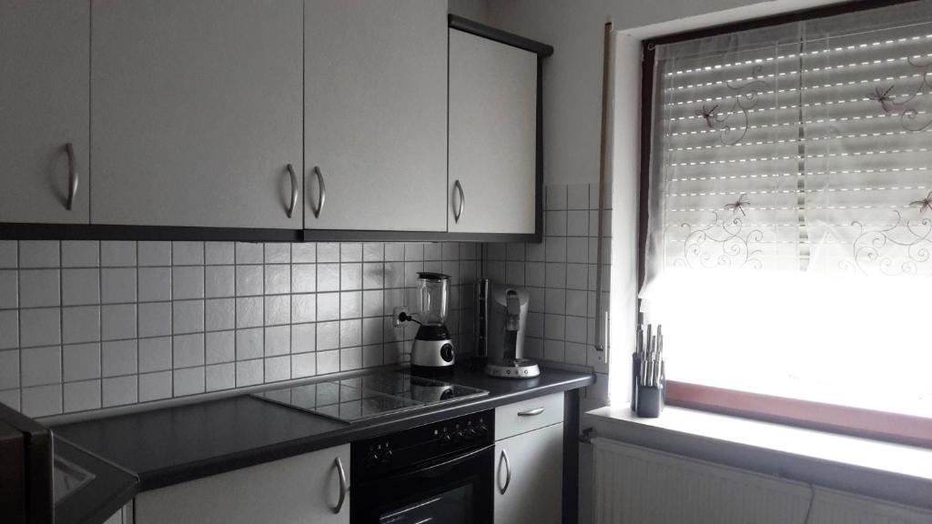 eine Küche mit weißen Schränken und einem schwarzen Herd in der Unterkunft Ferienwohnung Claudia & Dino in Lahnstein