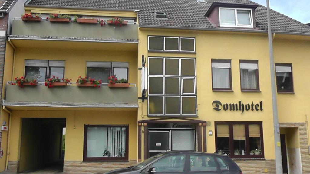 ein gelbes Gebäude mit einem davor geparkt in der Unterkunft Domhotel Bed & Breakfast in Schleswig