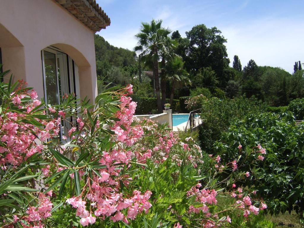 un jardín con flores rosas frente a una casa en Au vallon rouge (Suite double), en Saint-Paul-de-Vence