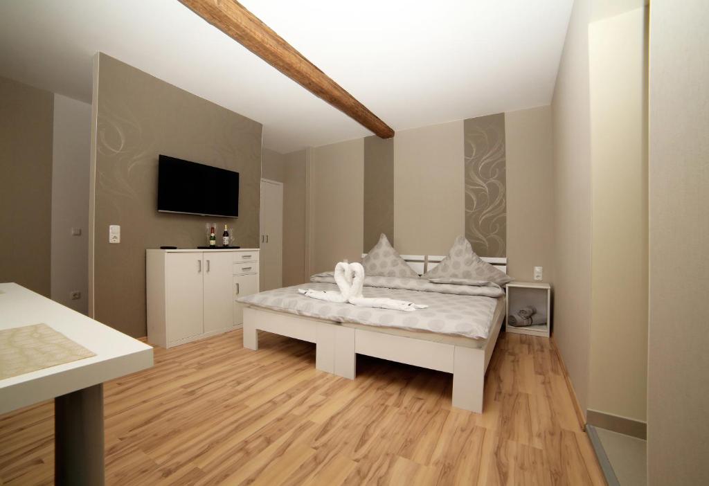 ein Schlafzimmer mit einem weißen Bett und einem Fernseher in der Unterkunft Haus am See Rossbach in Roßbach