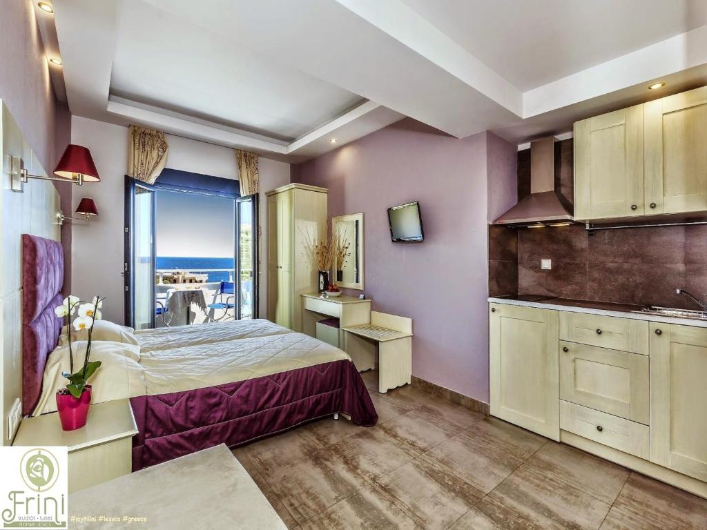 a bedroom with a bed and a kitchen with a view at Frini Studios in Plomarion