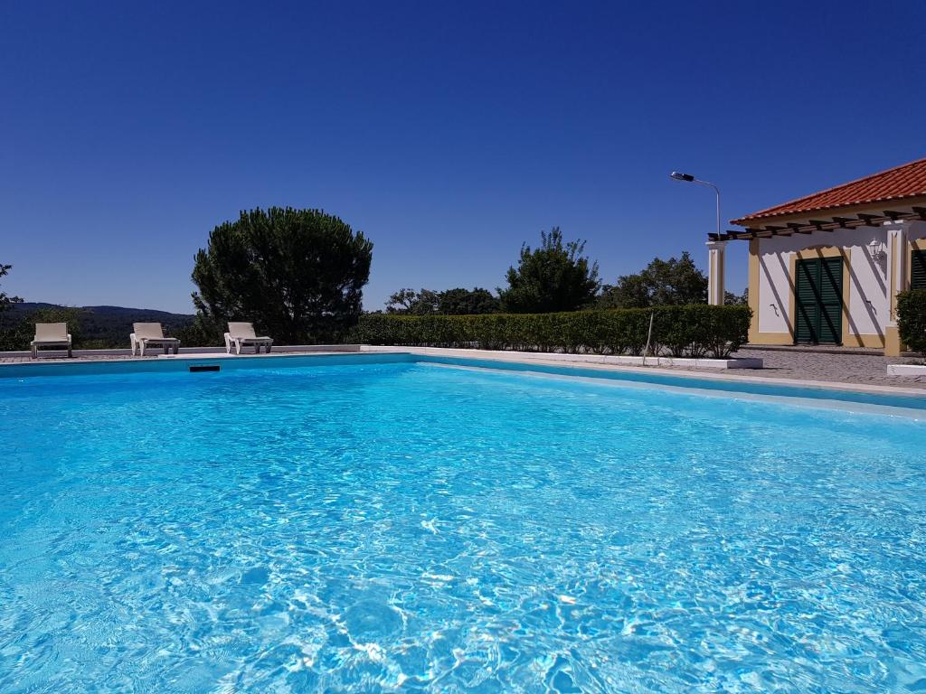 a large swimming pool with a blue sky at Quinta da Nave do Lobo in Marvão