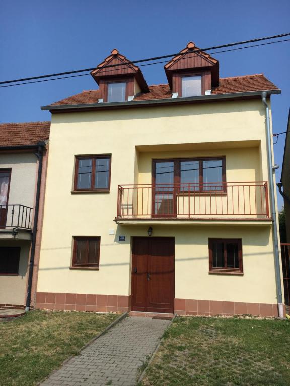 ヴェルケー・ビーロヴィツェにあるVinný Sklep Monty Velké Bíloviceのバルコニー付きの大きな黄色の家