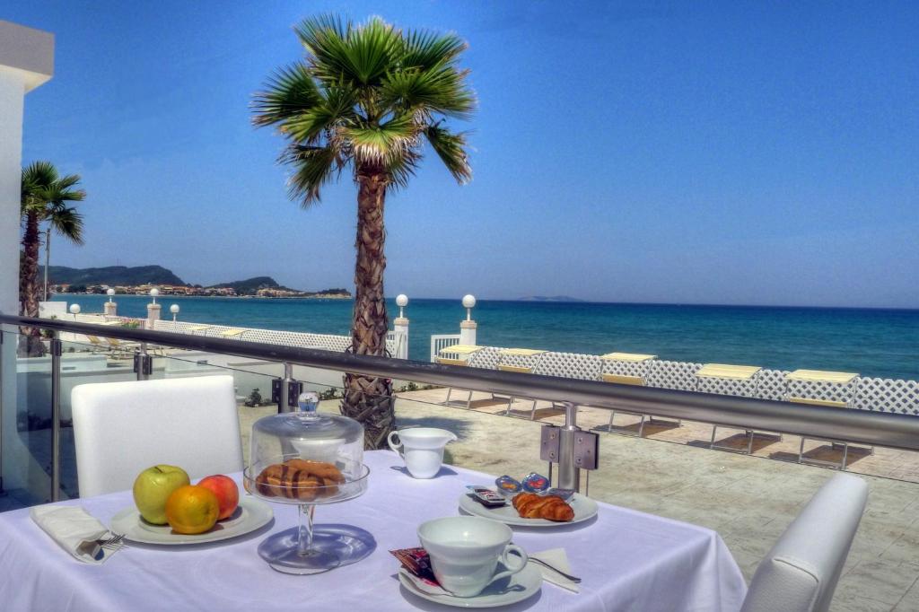 
a table with a white tablecloth and a blue umbrella at Sidari Beach Hotel in Sidari
