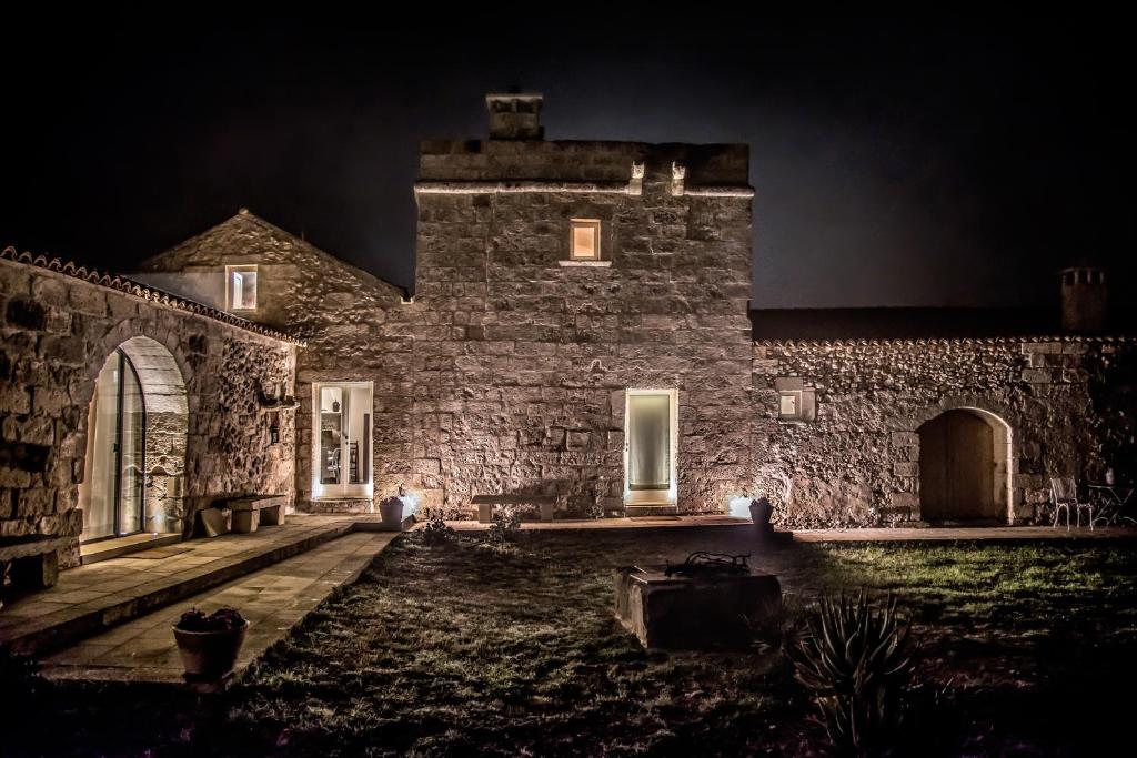 カルピニャーノ・サレンティーノにあるMasseria Maurianiの夜の灯り付きの古い石造りの家