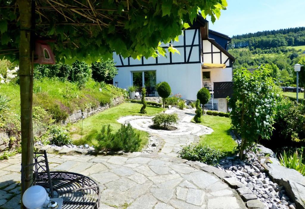 un jardin avec une passerelle en pierre en face d'une maison dans l'établissement Ferienwohnung rundumgruen, à Olpe