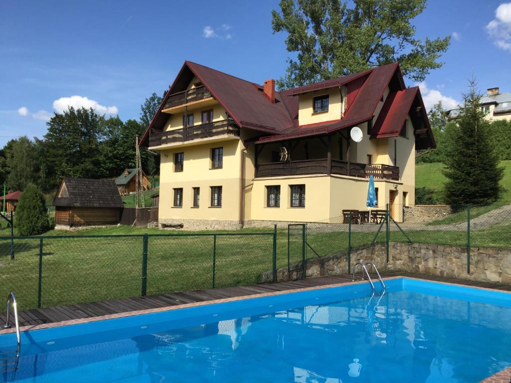 a house with a pool in front of it at Mylak BIANCA in Korbielów